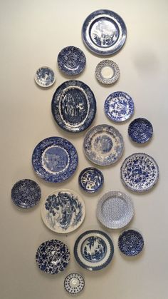 a collection of blue and white plates arranged in the shape of a pyramid on a wall