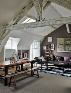 a living room filled with furniture and wooden beams