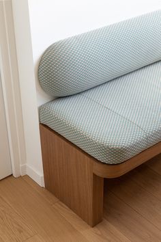 a close up of a wooden bench with a blue seat cushion on the bottom half