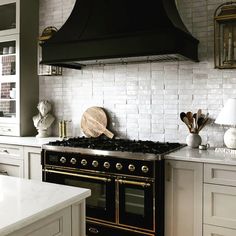 a black stove top oven sitting inside of a kitchen next to white counter tops and cabinets