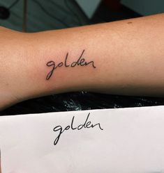 a person's arm with the word golden tattooed on it in cursive writing