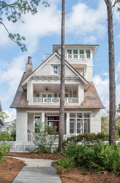 a white house surrounded by trees and bushes