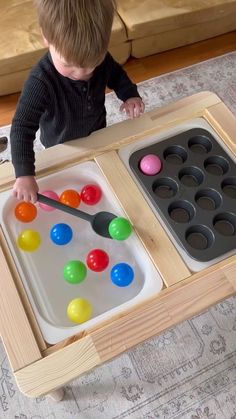 a young boy is playing with an egg tray