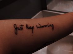 a person with a tattoo on their arm that says just keep swimming