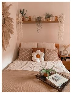 a bed with pillows and plants on the headboard