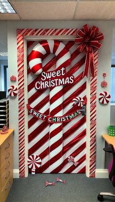 an office decorated for christmas with giant candy canes and sweet christmas message on the door