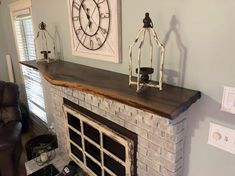 a living room with a brick fireplace and large clock on the wall above it's mantle