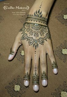 a woman's hand with henna tattoos on it