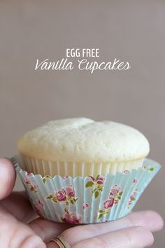 an egg free vanilla cupcake is shown in the palm of someone's hand