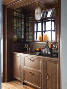 a kitchen with wooden cabinetry and glass front cabinets, along with a chandelier hanging from the ceiling