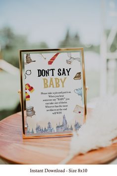 a don't say baby sign sitting on top of a wooden table