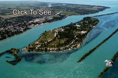 an aerial view of a small island in the middle of blue water with text that reads, click to see