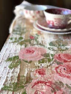 the table is covered with an old - fashioned cloth and has pink flowers on it