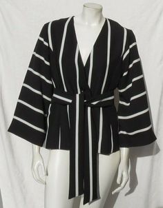 $168 NEW BANANA REPUBLIC Women’s Black White Stripe Belted Wide Sleeves Jacket US S 4 Fabulous striped jacket by BANANA REPUBLIC. Made of poly crepe, this jacket features drop shoulders, wide sleeves and a sash belt. Retail $168. Single button front. Long wide sleeves. Two welted hand pockets. Fully lined. Color: black with white stripe Fabric: 100% polyester Care:  dry clean Tagged US women’s size 4 – see actual measurements Chest (underarm-to-underarm, doubled): 36”, waist: 35” (cinch with bel Black And White Jacket, Stripe Fabric, Sash Belts, Sash Belt, Striped Jacket, Banana Republic Women, Striped Fabrics, Wide Sleeves, Vest Jacket