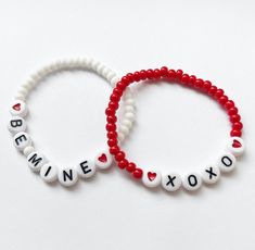 two red and white beaded bracelets with the words be mine to xoxo