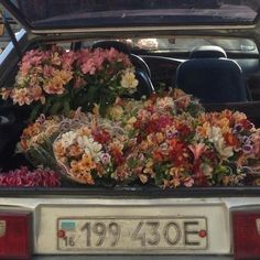 the back end of a car with flowers in it