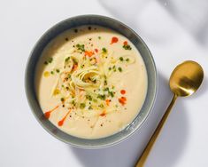 there is a bowl of soup with noodles in it and a spoon next to it