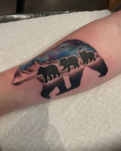 an elephant tattoo on the arm with other animals in it's silhouettes and colors