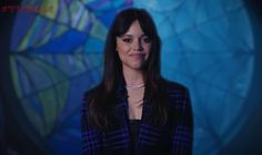 a woman standing in front of a blue background