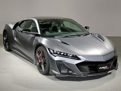 a silver sports car parked in a white room