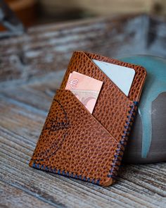 The Timidus card wallet is the perfect choice if you aim at carrying only your daily essentials.  Its fold-over design hints at the curves of the unique Othus twist wallet, yet gives countless colour combination possibilities as well as an extra card slot.  The vertical design of the Timidus also holds your cards more tightly than the horizontal Othus. The Timidus is a 4-slot card wallet. It will hold 6 to 7 cards and some cash from new, while ageing of the leather will allow for another card or two over time.  The Timidus measures 7,5 x 10cm. I only use leather that is 100% vegetable tanned with respect for tradition and our environment. No chemicals are used in the production process, and only left over skins from the food industry are used. This Timidus card wallet is made of Dollaro le Cognac Trifold Wallet With Card Slots For Everyday Use, Modern Cognac Wallets With Card Slots, Cognac Card Holder With Rfid Blocking For Everyday Use, Modern Brown Card Holder For Everyday Carry, Cognac Rfid Blocking Card Holder For Everyday Use, Modern Handmade Brown Card Holder, Brown Modern Card Holder, Modern Handmade Card Holder For Daily Use, Modern Handmade Brown Wallets