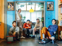 a group of people are sitting in a room with blue walls and pictures on the wall