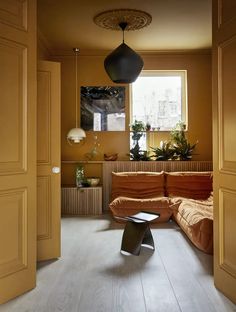 an orange couch sitting in front of a window