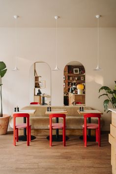 a living room filled with lots of furniture next to a mirror and potted plant