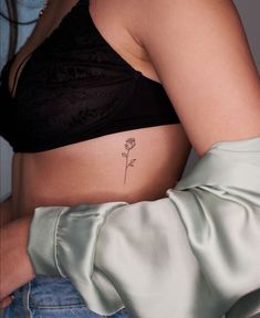 a woman's stomach with a flower tattoo on it