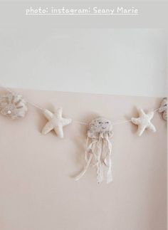 there are three starfishs hanging on the wall and one is made out of shells