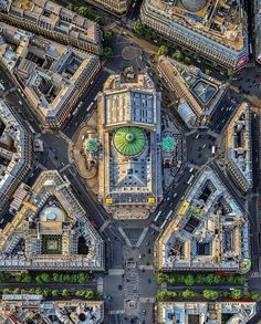 an aerial view of a city with lots of tall buildings and green domes on top