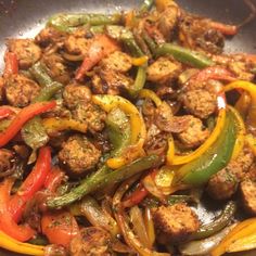 a pan filled with meat, peppers and onions