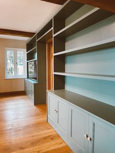 an empty room with wooden floors and built - in shelving units on the wall