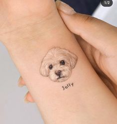 a small white dog on the wrist with an inscription written below it that says jolly