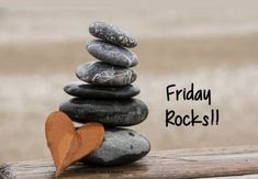 a pile of rocks sitting on top of a wooden table next to a red heart