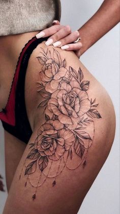 a close up of a person's thigh with tattoos on it and flowers in the middle