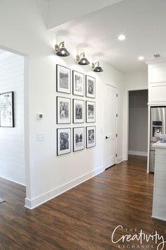 an empty room with pictures on the wall and hard wood flooring in front of it