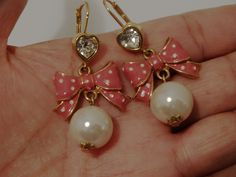 "The earrings are gold-tone metal featuring a pink bow and one large faux pearl, size 2 1/2\" inch long x 1\" inch wide, pearl size 15mm in excellent condition." Pink Bow Earrings In Cute Style, Cute Pink Earrings With Pink Bow, Elegant Pink Bow Earrings For Party, Cute Gold Bow Earrings, Cute Bow Earrings For Wedding, Cute Pink Bow Earrings For Party, Elegant Gold Jewelry With Pink Bow, Pink Heart-shaped Jewelry With Bow, Bow Earring