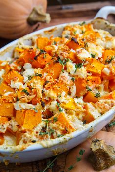 a casserole dish with carrots, cheese and herbs