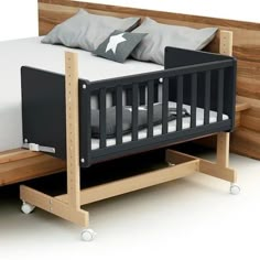 a baby crib that is made out of wood and has two pillows on it