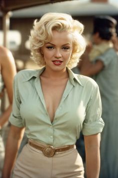 a woman with short blonde hair wearing a green shirt and tan pants is posing for the camera