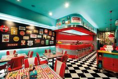 the interior of a diner with checkered tables and red booths, black and white flooring