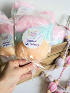 a person holding a bag of cake in front of some other cakes on a shelf