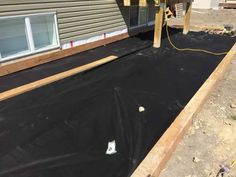 a house being built with black tarp on the ground