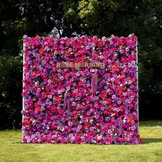 a pink and purple flower wall in the grass