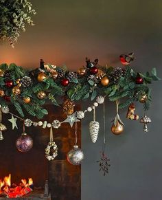 christmas decorations hanging from the ceiling next to a fire place