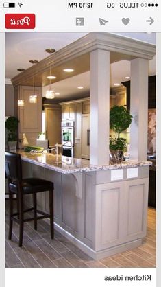 a kitchen with an island in the middle and two bar stools at the end