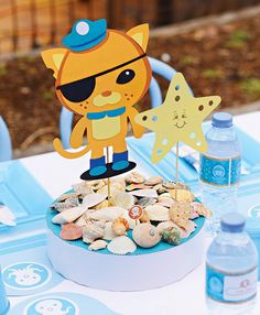 a table topped with a cake covered in lots of sea shells and starfish decorations