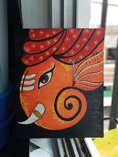 an orange and black painting on a window sill