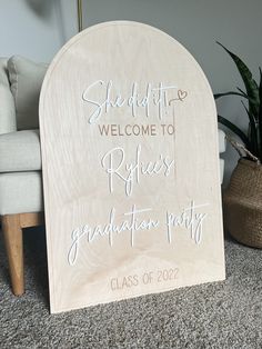 a wooden welcome sign sitting on top of a carpeted floor